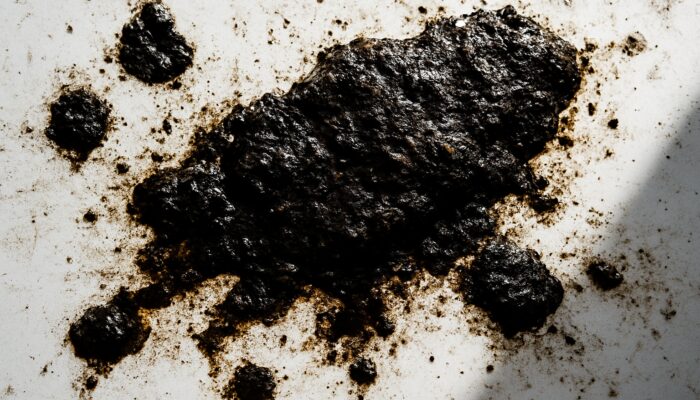 Close-up of white surface with dark oily residue patches and grime buildup